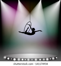 Aerial acrobat woman on circus stage with spotlights