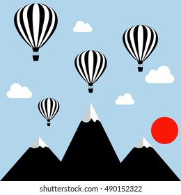 aerostats flying in the sky over the mountains at sunset
