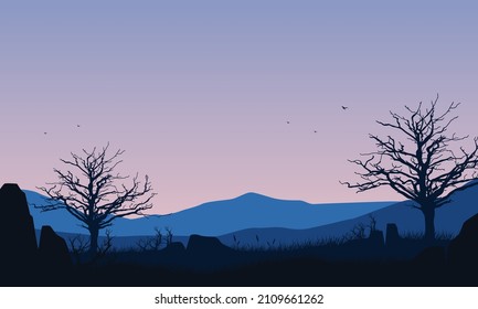 Aesthetic mountain view with dry tree silhouette from out of the village at sunset
