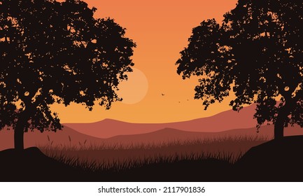 Aesthetically beautiful view of mountains with silhouettes of trees in the evening from the edge of town