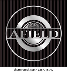 Afield silvery emblem or badge
