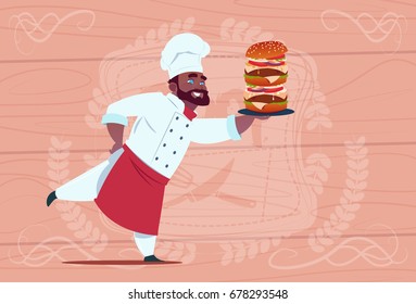 African American Chef Cook Hold Big Burger Smiling Cartoon Restaurant Chief In White Uniform Over Wooden Textured Background Flat Vector Illustration
