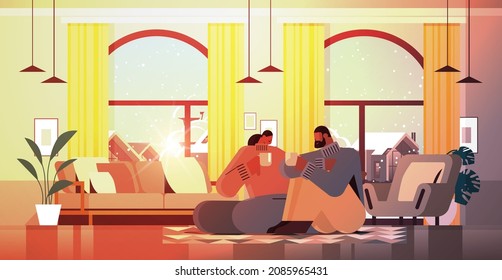 african american couple drinking coffee and talking together at home living room interior horizontal
