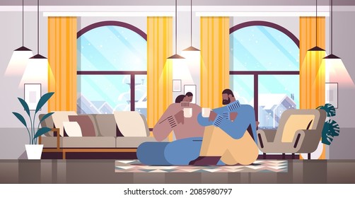 african american couple drinking coffee and talking together at home living room interior horizontal
