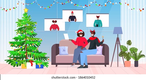 african american couple in masks discussing with friends during video call coronavirus quarantine concept new year christmas holidays celebration living room interior horizontal full length vector