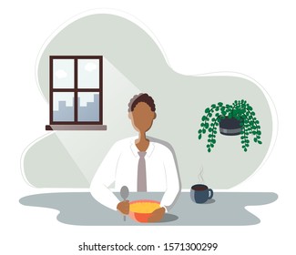 African American eating food, young man sitting at the table and having breakfast. In a bowl of porridge, next to a Cup of hot tea or coffee. The sun shines brightly through the window.