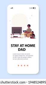 african american father playing video games on game console with little son parenting fatherhood concept