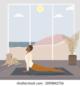 African american man is doing Upward Facing Dog or Urdha Mukha Shvanasana posture at the room with a dog, with beautiful view on nature: sea, mountains, sun, sky)