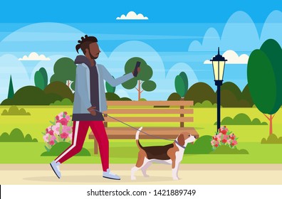 african american man walking with dog using smartphone social media network communication digital gadget addiction concept city urban park landscape background flat full length horizontal