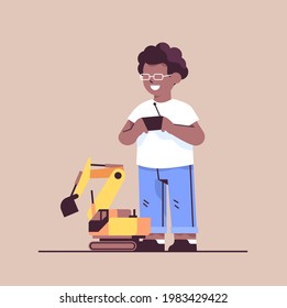 african american schoolboy playing with radio controlled tractor toy smiling boy having fun
