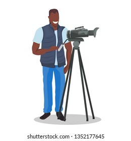 african american television operator using video camera on tripod happy cameraman looking through camcorder movie making concept flat full length