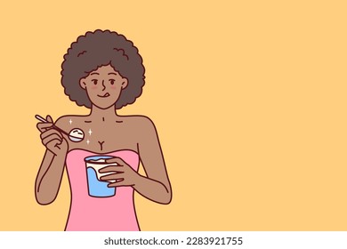 African American woman eating ice cream enjoying cold dessert to cool down after hot walk. Curly ethnic girl with ice cream satisfies hunger and licks lips wanting to be refreshed in summer weather 