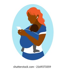 An African American woman uses a smartphone while holding a baby in a kangaroo bag. Wearing in a sling. Mother's free hands. Newborn laid back nursing care. 