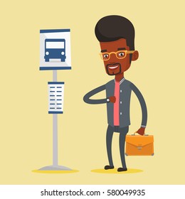 African business man with briefcase waiting at the bus stop. Young business man standing at the bus stop. Man looking at his watch at the bus stop. Vector flat design illustration. Square layout.