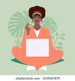 African business woman sitting comfortably with a laptop and a pencil, surrounded by plants 