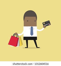 African businessman with credit card and shopping bags.