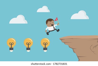 African businessman crosses a high cliff with light bulbs, showing his intelligence. His hand holding a red flag