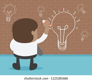 African businessman hand with a pen drawing light bulb