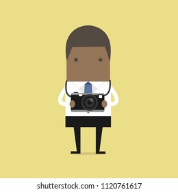 African businessman holding a camera.
