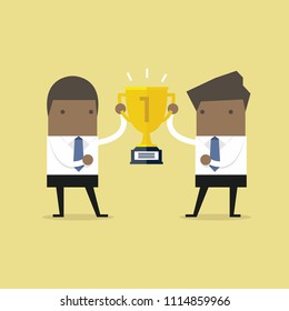 African businessman holding gold winner cup together.