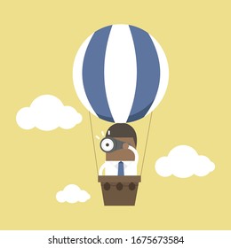 African businessman look at binoculars on balloons that are floating in the sky.