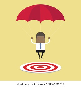 African businessman with parachute focused on a target.