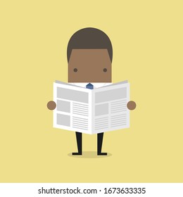 African businessman standing and reading a newspaper.