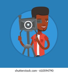 African cameraman looking through movie camera on a tripod. Cameraman with professional video camera. Cameraman taking a video. Vector flat design illustration in the circle isolated on background.