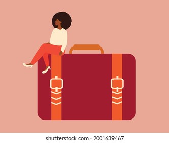 African entrepreneur woman sits on a big handbag with confidence and proud. A black businesswoman looks smart and strong with a business briefcase. Leadership, management, women empowerment concept.