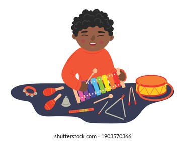 African ethnicity boy playing xylophone on the table. Kids' wooden musical instruments. Children musical and creativity development concept. 