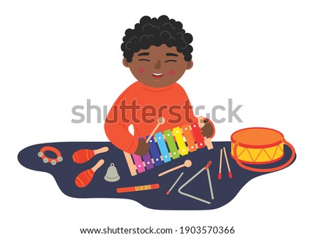 African ethnicity boy playing xylophone on the table. Kids