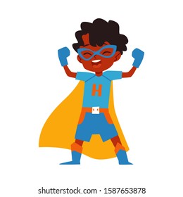 African kid little boy superhero costume standing raised arms cartoon style, vector illustration isolated on white background. Boy child dressed in yellow cape and blue mask and gloves in winner pose