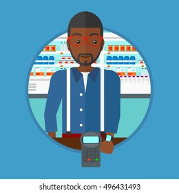 An african man paying wireless with his smart watch at the supermarket. Customer making payment for purchase with smart watch. Vector flat design illustration in the circle isolated on background.