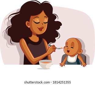 African Mother Feeding Her Baby Solid Food with a Spoon. Loving mom introducing new recipe to her child
