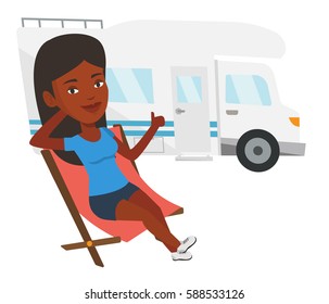 African woman sitting in a folding chair and giving thumb up on the background of camper van. Woman enjoying her vacation in camper van. Vector flat design illustration isolated on white background.