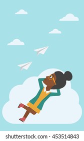 An african-american business woman lying on a cloud and looking at flying paper plane. Business woman relaxing on a cloud. Vector flat design illustration. Vertical layout.