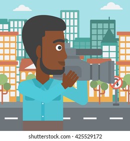 An african-american cameraman with video camera taking a video on a city background vector flat design illustration. Square layout.