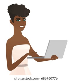 African-american cheerful bride in a white dress using a laptop. Happy bride working on a laptop. Young smiling bride holding a laptop. Vector flat design illustration isolated on white background.