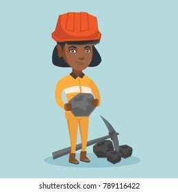 African-american female miner in hard hat holding a piece of coal in hands. Young smiling miner in workwear standing near a pickaxe and coal. Vector cartoon illustration. Square layout.