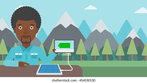 An african-american man charging tablet computer with solar panel on the background of mountains. Charging digital tablet from portable solar panel. Vector flat design illustration. Horizontal layout.