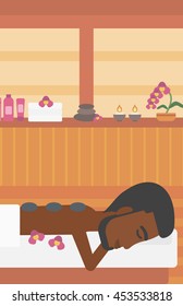An african-american man relaxing while getting stone therapy massage in the spa center. Man having back massage in spa salon. Vector flat design illustration. Vertical layout.