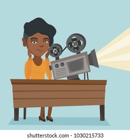 African-american projectionist sitting at the table with film projector. Young projectionist showing a new film. Vector cartoon illustration. Square layout.