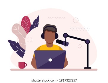 African-american radio host sitting in front of microphone. Young man in headset working at the radio studio.