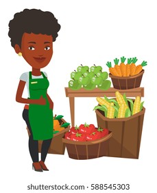 African-american supermarket worker giving thumb up. Supermarket worker standing on the background of shelves with vegetables and fruits. Vector flat design illustration isolated on white background.