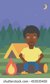 An african-american travelling man sitting on a log near a fire on a background of camping site with tent. Man sitting near a campfire at a campsite. Vector flat design illustration. Vertical layout.