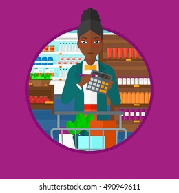 An african-american woman with calculator and supermarket trolley full with products. Woman checking prices with calculator. Vector flat design illustration in the circle isolated on background.