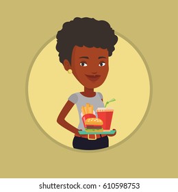 African-american woman holding tray with fast food. Woman having a lunch in a fast food restaurant. Happy woman with fast food. Vector flat design illustration in the circle isolated on background.