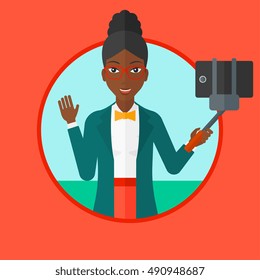 African-american woman making selfie with a selfie-stick. Woman taking photo with cellphone. Young woman taking selfie and waving. Vector flat design illustration in the circle isolated on background.