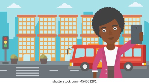 An african-american woman making selfie. Woman taking photo with cellphone. Woman looking at smartphone and taking selfie on the background of city. Vector flat design illustration. Horizontal layout.