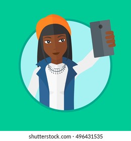 An african-american woman making selfie. Young woman taking photo with cellphone. Woman looking at smartphone and taking selfie. Vector flat design illustration in the circle isolated on background.